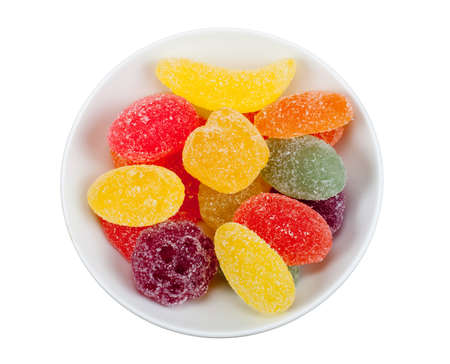 bowl of fruit candy in many colors isolated on a white background