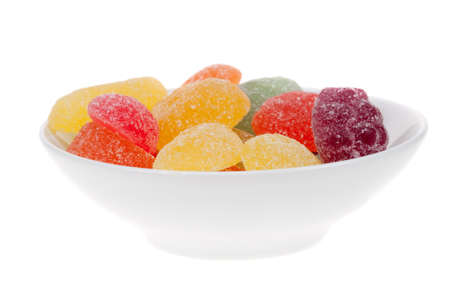 bowl of fruit candy in many colors isolated on a white backgroundの写真素材