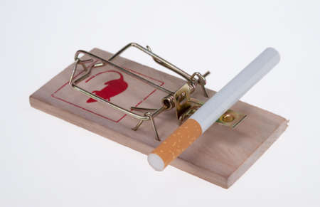 conceptual image of  a cigarette on a mouse trap isolated on a white backgroundの写真素材