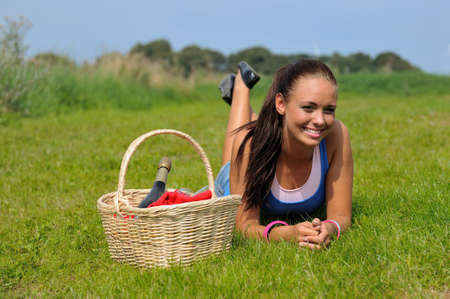young attractive woman and bottle of champagne in summerの写真素材