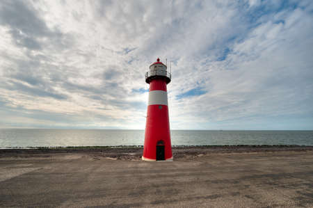 Red and white lighthouse in Zeeland the Netherlandsの写真素材