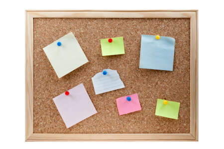 different sticky notes on a cork board isolated on a white backgroundの写真素材