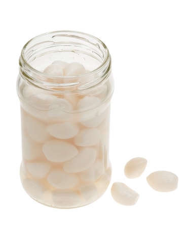 A jar of garlic pieces isolated on a white backgroundの写真素材