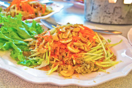 Spicy fried Thai tilapia fish salad minced meat with vegetable,thai foodの写真素材