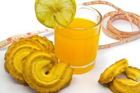 Cup Of Orange Juice With Cookies and  measuring tape isolated on white background  の写真素材