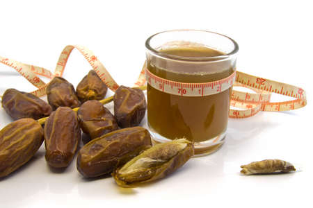 Measuring Tape around dates fruits  juiceis cup and  dates fruits  Isolated on whiteの写真素材