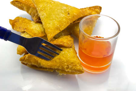 Typical food in Thaialnd  many traditional Thai Samoosas with Chili sauce  triangle-shaped pastries  stuffed with chicken and beef mince with lettuce on plate on white background の写真素材