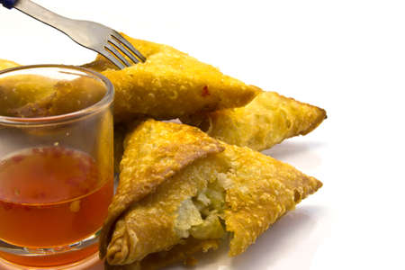Typical food in Thaialnd  many traditional Thai Samoosas with Chili sauce  triangle-shaped pastries  stuffed with chicken and beef mince with lettuce on plate isolated on white background の写真素材
