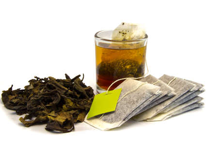 Dried tea with teabag  and cup  on white bacground の写真素材