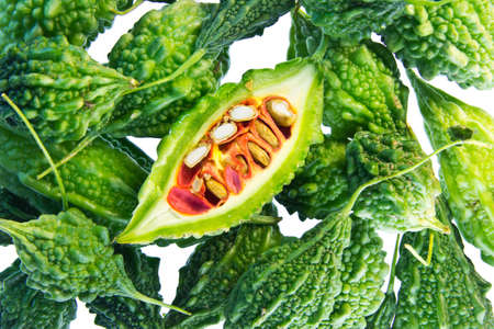 Closeup photo of fresh  Bitter Cucumber  Balsum Pear  cut in half, isolated on white backgroundの写真素材