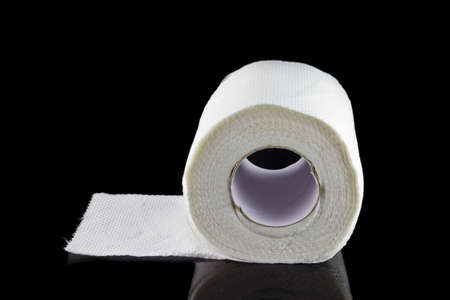 White toilet paper roll isolated on black backgroundの写真素材