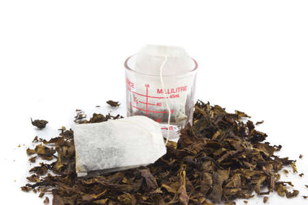two tea bags over dried tea leaves backgroundの写真素材