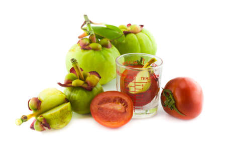 Fresh red tomatoes and garcinia isolated on whiteの写真素材