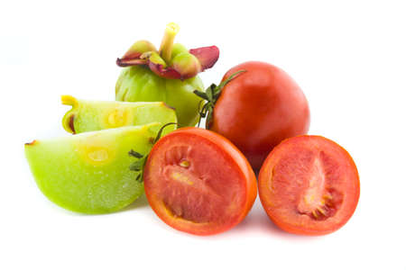 Fresh red tomatoes and garcinia isolated on whiteの写真素材