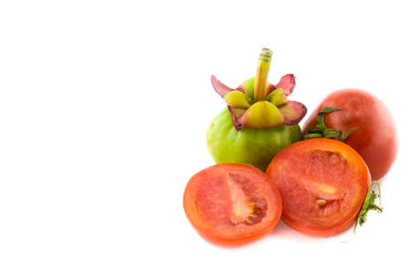 Fresh red tomatoes and garcinia isolated on whiteの写真素材