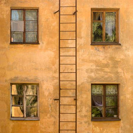 facade  of old orange colorful living house with four windows and pompierの写真素材