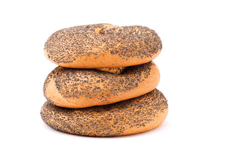 Three bagels with poppy seeds lying on each other isolated on whiteの写真素材