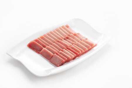 Slices of raw pork on white plate isolated on white backgroundの写真素材
