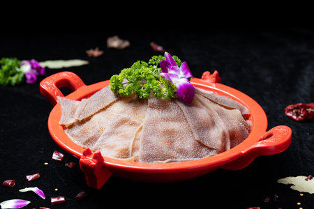 Raw fish fillet in a red plate on a black background.の写真素材