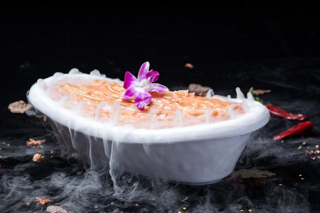 Thai dessert in a white bowl on a black background with orchidの写真素材