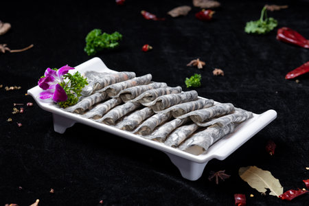 dried anchovies on a white plate with herbs on a black backgroundの写真素材