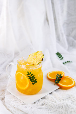 Orange juice with ice and mint in a glass on a white backgroundの写真素材