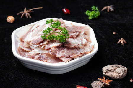 Slices of Raw Pork with Parsley on a Black Backgroundの写真素材