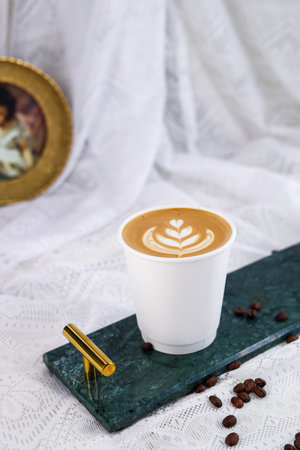 Coffee cup with latte art on white fabric background.の写真素材