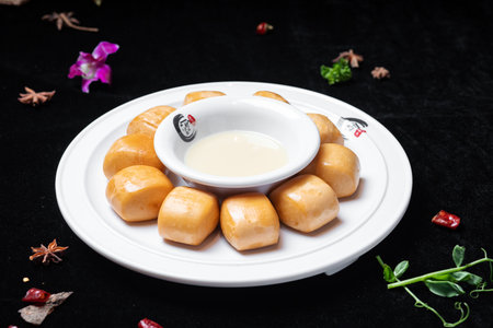Dumplings with condensed milk on a white plate on a black backgroundの写真素材