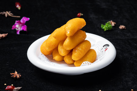Deep-fried dough stick on a white plate on a black backgroundの写真素材