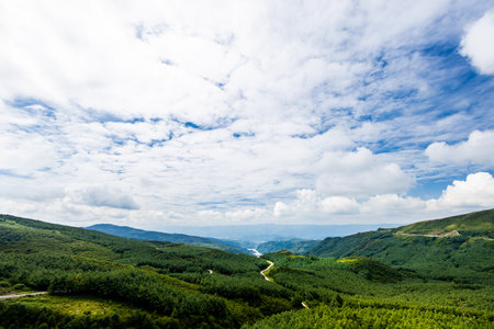 Landscape of green mountain under the blue sky with white clouds.の写真素材