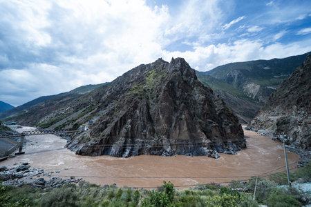 Landscape view of a river flowing through the mountains under cloudy skyの写真素材