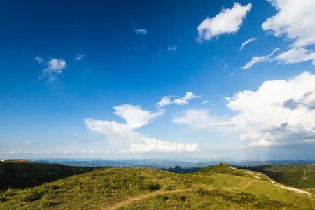 Mountain landscape under the blue sky with white clouds. Green hills.の写真素材