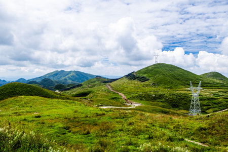 High-voltage power lines in the mountains under the blue skyの写真素材