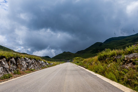 Landscape of a road in the mountains under a cloudy sky.の写真素材