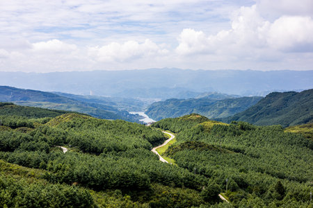 Aerial view of green mountain landscape with blue sky and white cloudsの写真素材