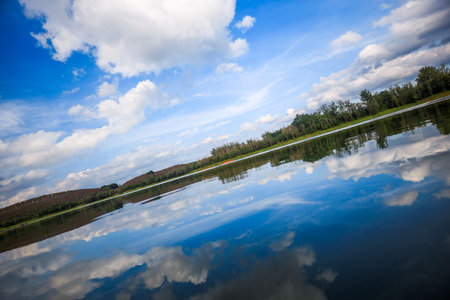 Reflection of clouds in the water of a lake. Nature composition.の写真素材