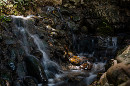 Waterfall in the forest in the mountains. Beautiful natural background.の写真素材