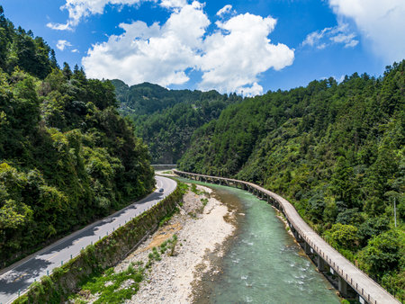 Mountain road in the valley with blue sky and white clouds.の写真素材