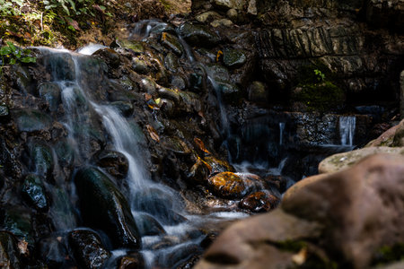 Waterfall in the forest, close up of water flowing over rocksの写真素材