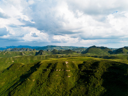 Aerial view of the green hills and blue sky with white cloudsの写真素材