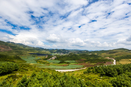 Aerial view of green mountain with blue sky and white clouds.の写真素材