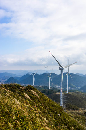Wind turbines generating electricity on the hillside with blue sky background.の写真素材