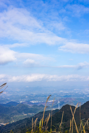 Landscape view of mountain with wind turbine on blue sky background.の写真素材