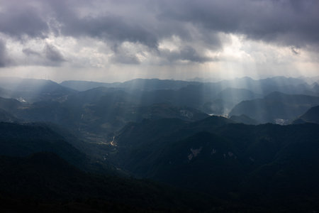 Sun rays passing through the clouds over the mountains.の写真素材