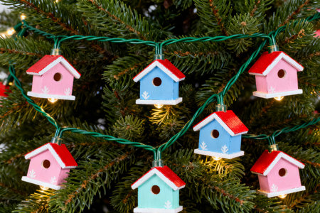 Christmas tree decorated with colorful wooden birdhouses and garland, closeupの素材