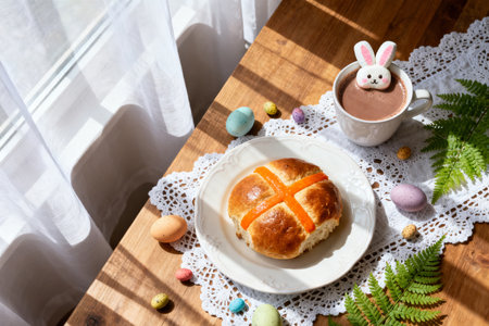 Easter hot cross buns, cup of hot chocolate and Easter eggs on wooden tableの素材