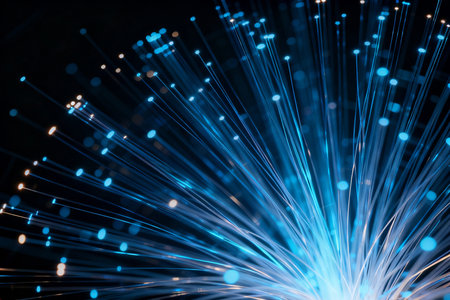 Fiber optical network cable close-up with blue light rays.の素材