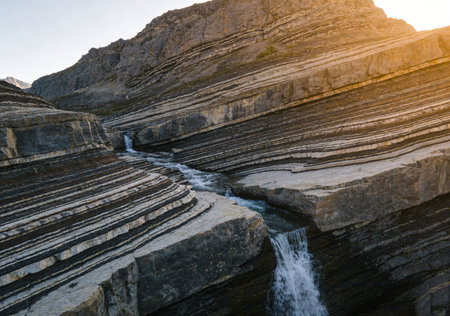 Beautiful view of a small waterfall in the mountains at sunset.の素材