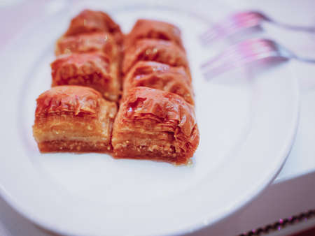 Sweet Turkish baklava on a plate with forks on the sideの写真素材